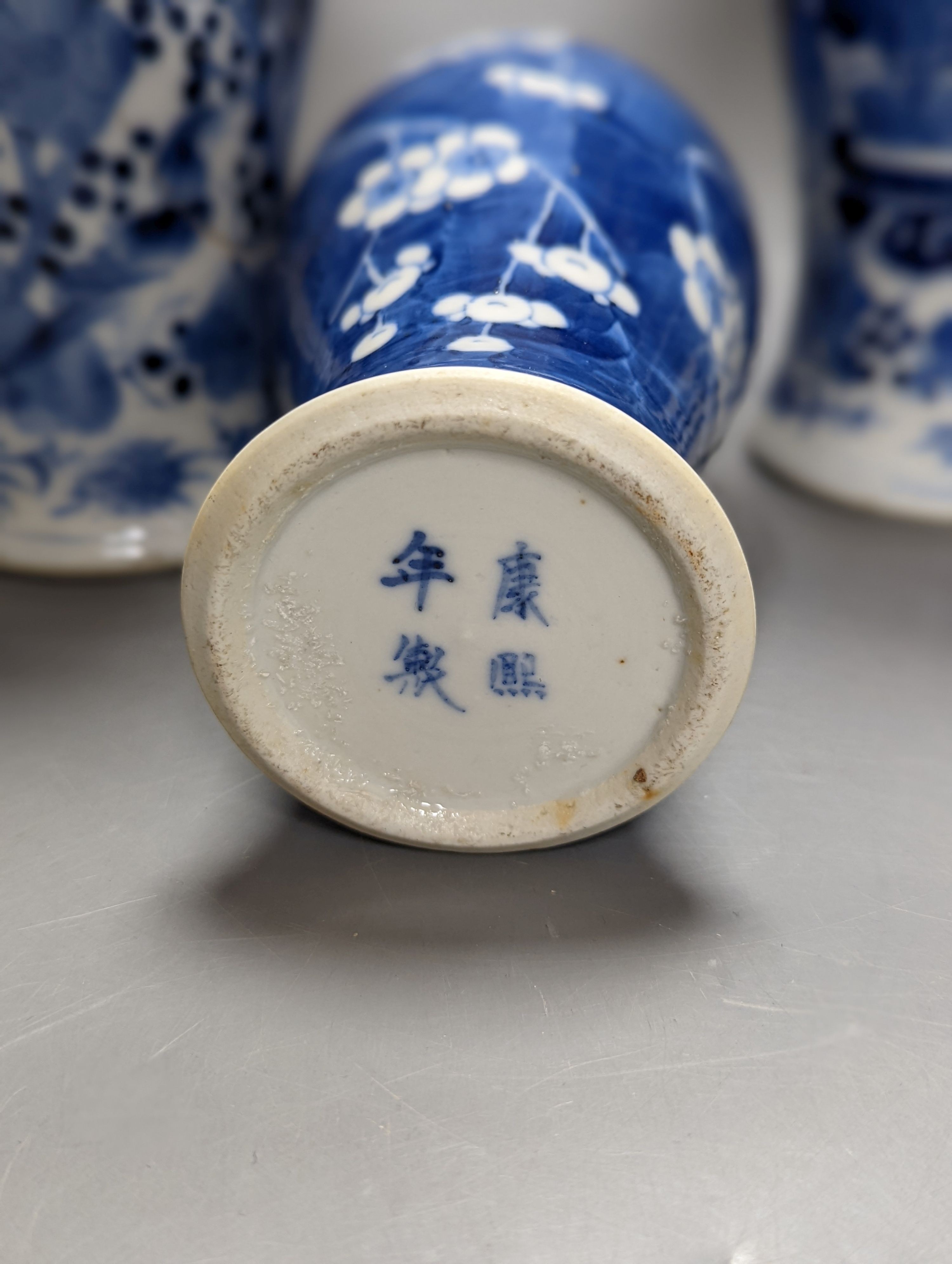 A pair of 19th century Chinese blue and white vases, a prunus vase and cover and a similar jar (4), pair of vases 24 cms high.